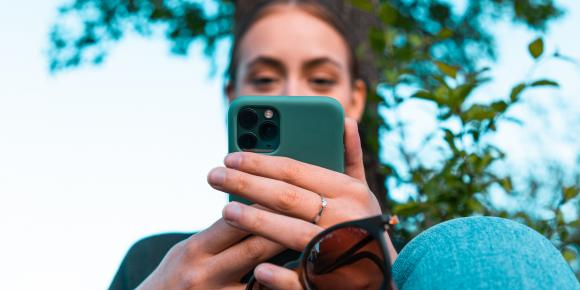 Junge Frau spielt am Handy.